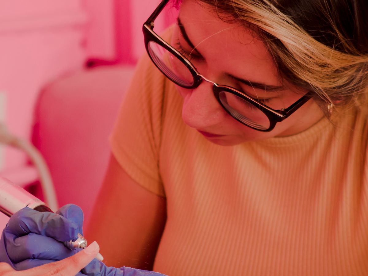 A confident nail technician working with a client.