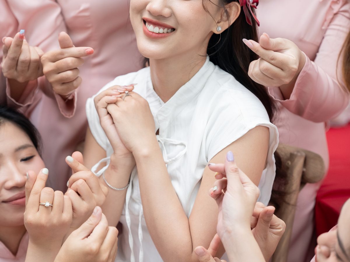 A bride and her friends celebrating together before the wedding, showing off their nails.
